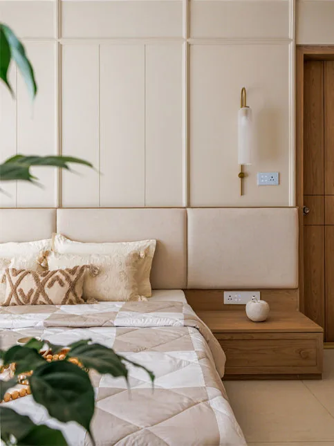 Master bedroom detail with fabric wall panelling and oak nightstands - Beautiful Homes