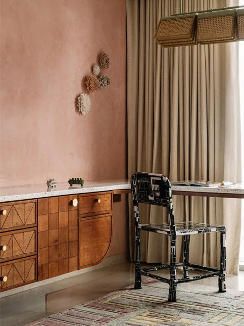 Memory-led lounge with wall objects rugs and chairs in Byculla home - Beautiful Homes